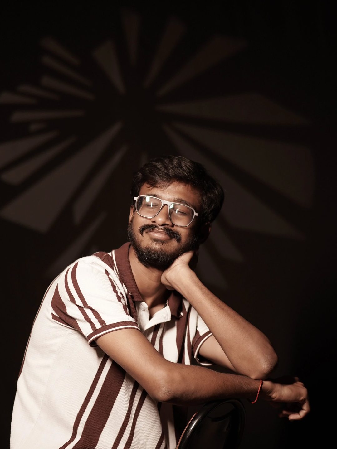 Low-key studio portrait against a patterned backdrop