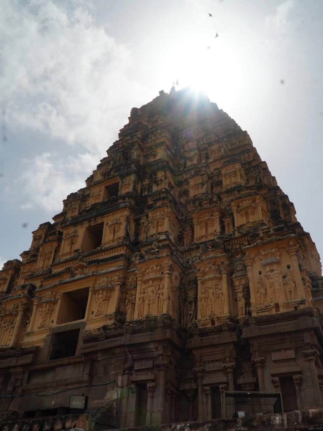 Sun bursting over an ancient Hampi temple